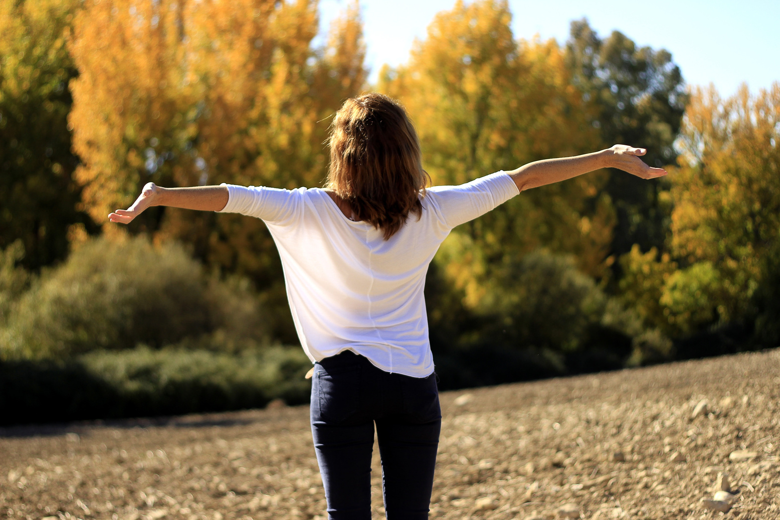 Woman in Wide Open Arms Facing the Sunlight